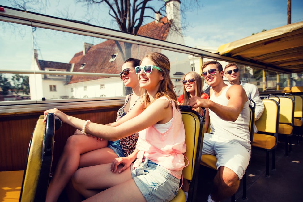 Group of Smiling Friends Traveling by Tour Bus